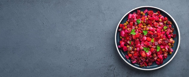 Vegetable salad with beetroot pickled cucumbers and peas on a dark background