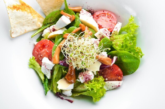 Vegetable salad with brie cheese cherry tomatoes and spinach In the plate Top view Free space for your text Rustic style