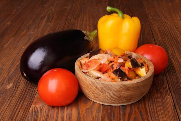 Vegetable salad with eggplant and other ingredients on a wooden table