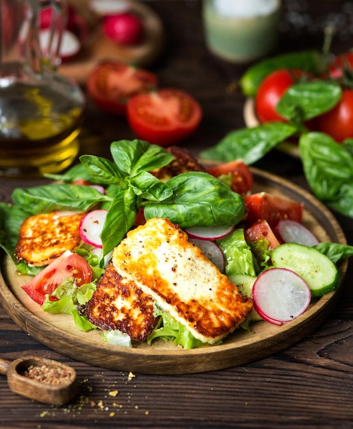 Vegetable salad with fried cheese Salad of fresh tomatoes radishes cucumbers basil Olive oil