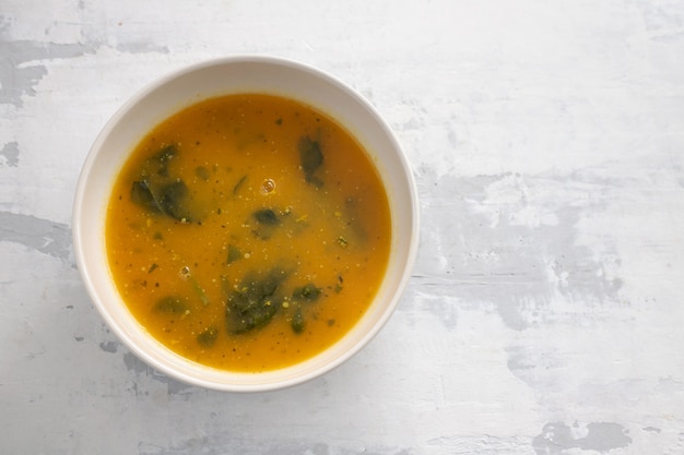 Vegetable soup in bowl on ceramic background