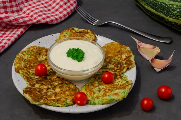 Vegetable zucchini pancakes served with yogurt sauce. Ingredients for cooking