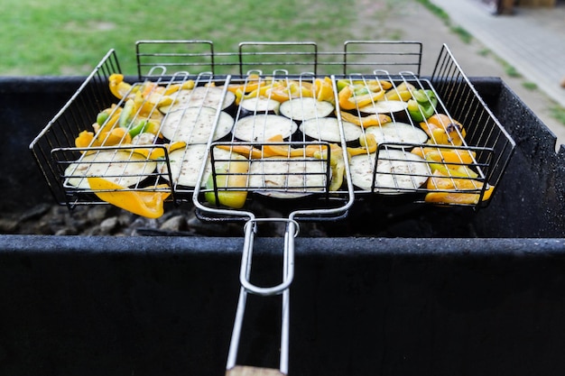 Vegetables on barbecue grill copy space Peppers and eggplants on an iron grate Horizontal photo