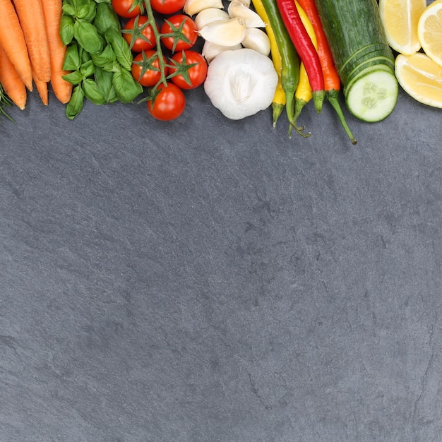 Vegetables collection tomatoes carrots cooking ingredients slate square copyspace background top view