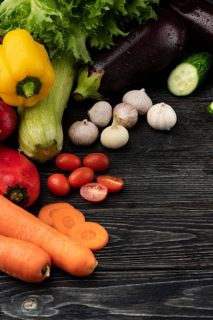 Vegetables on a dark wooden background, beautifully decorated still life of vegetables.