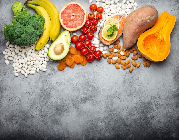 Vegetables, fruit and foods containing potassium, stone background, top view, space for text. Natural sources of potassium, vitamins and micronutrients, healthy balanced diet, avitaminosis prevention