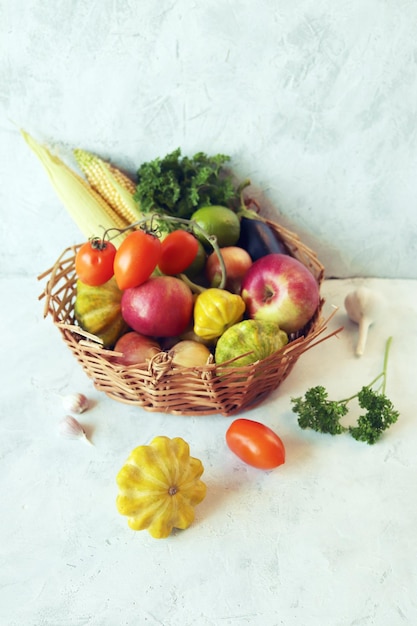 Vegetables fruits and greens in a wicker basket on the table harvest season