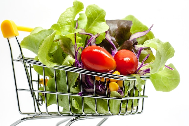 Vegetables in the shopping cart on white background