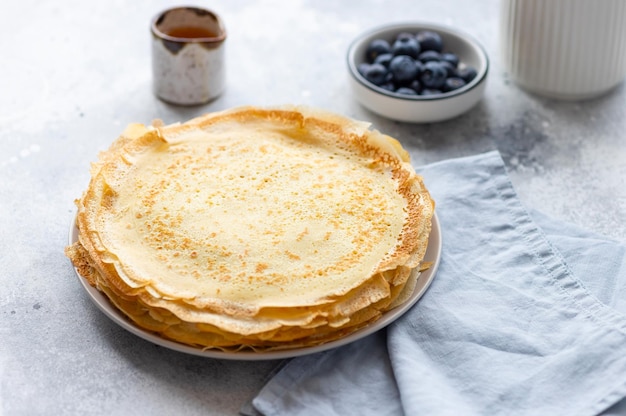 Vegetarian breakfast with crepes thin pancakes on gray background