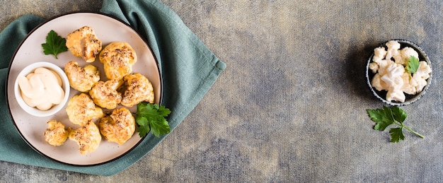 Vegetarian cauliflower buffalo wings and sauce on a plate on the table Top view Web banner