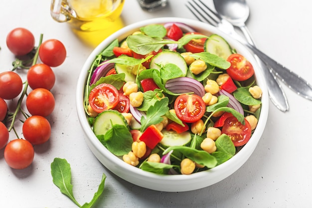 Vegetarian chickpea beans salad prepared with tomatoes, cucumber, red onion, cress salad and arugula. Chickpeas are rich in protein and fiber