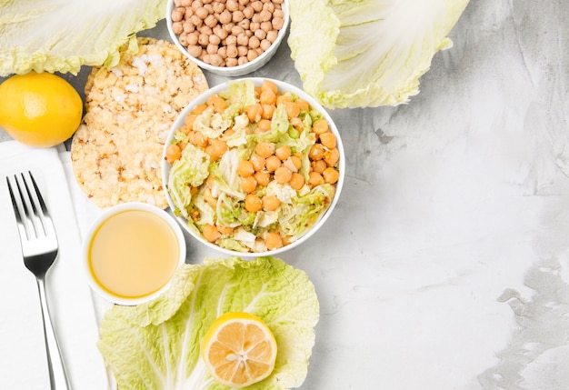 Vegetarian chickpea salad and ingredients on a concrete light background. 