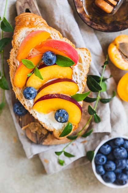 Vegetarian croissant sandwiches with nectarine soft or cream cheese blueberries and honey