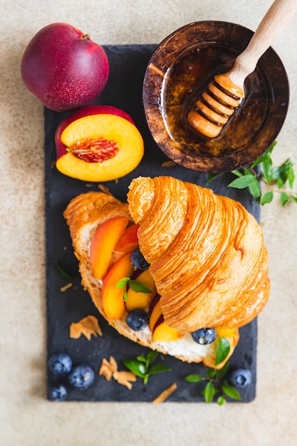 Vegetarian croissant sandwiches with nectarine soft or cream cheese blueberries and honey