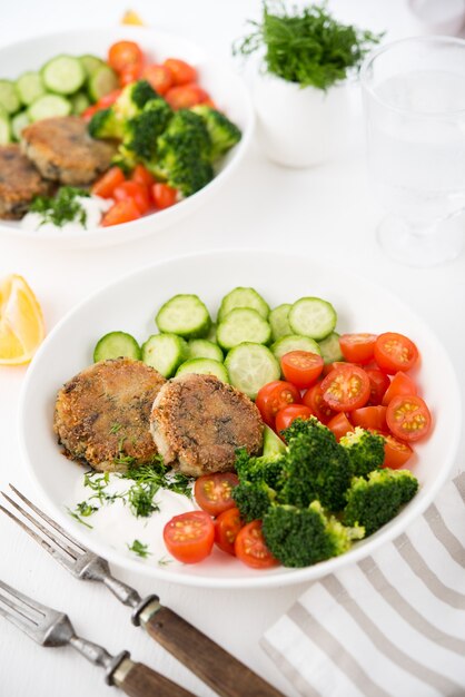 Vegetarian dish of potato patties with herbs and vegetables on a plate