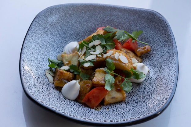 Vegetarian eggplant salad with baked aubergine cherry tomatoes and cilantro close up macro photo of