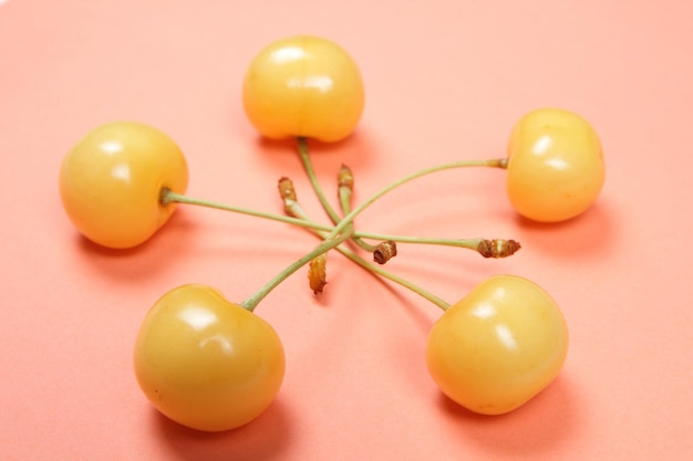 Vegetarian food concept Closeup Sweet juicy yellow cherries on a pink background View from above