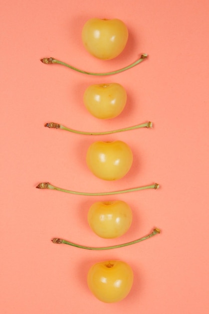 Vegetarian food concept Closeup Sweet juicy yellow cherries on a pink background View from above