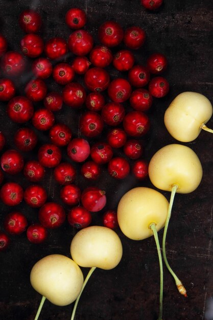 Vegetarian food concept Sweet juicy red currants and yellow cherries on a dark background View from above