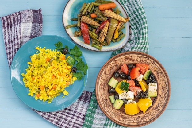 Vegetarian food pilaf and corn salad Greek salad with feta cheese drink with seeds top view