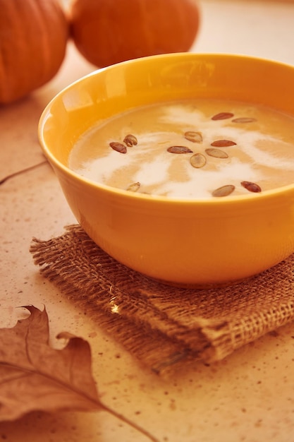 Vegetarian healthy autumn pumpkin creamesoup with seeds and plantbased cream