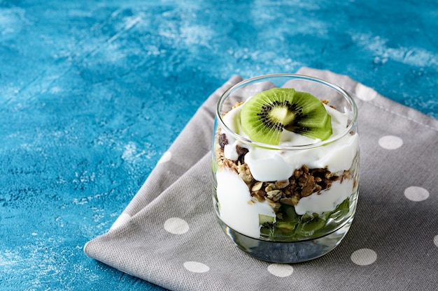 Vegetarian healthy dessert with kiwi, granola and whipped cottage cheese with polka dot napkin