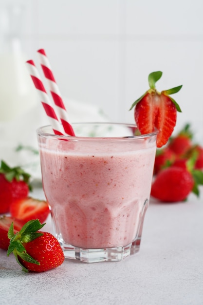 Vegetarian healthy smoothie from strawberry with berries on gray or white concrete background. Selective focus. Space for text.