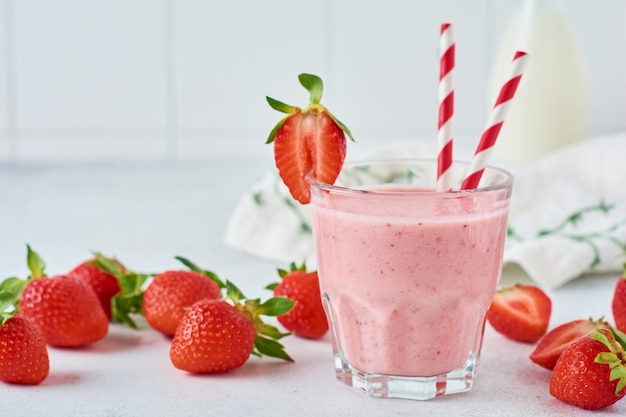 Vegetarian healthy smoothie from strawberry with berries on gray or white concrete background