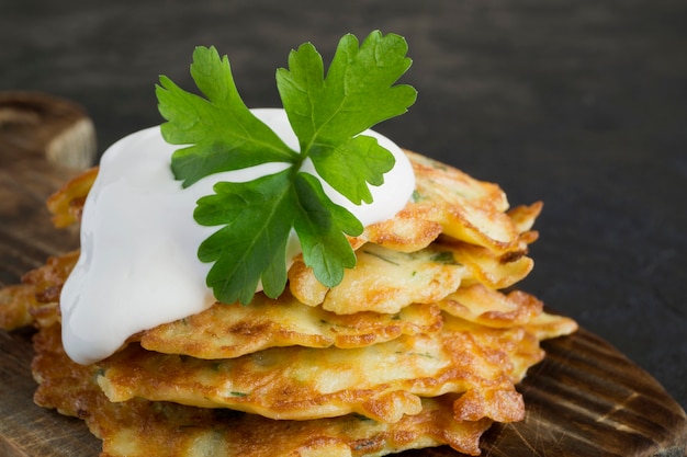 Vegetarian healthy zucchini pancakes with herbs and sour cream