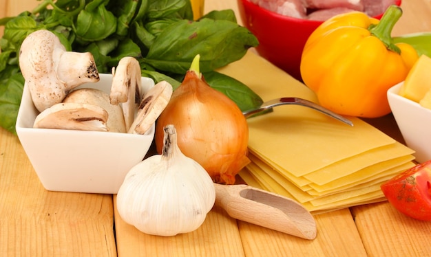 Vegetarian lasagna ingredients on wooden background