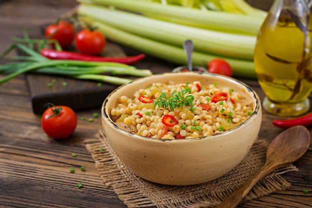 Vegetarian porridge from Turkish couscous with vegetables. Dietary menu. Vegan cuisine.