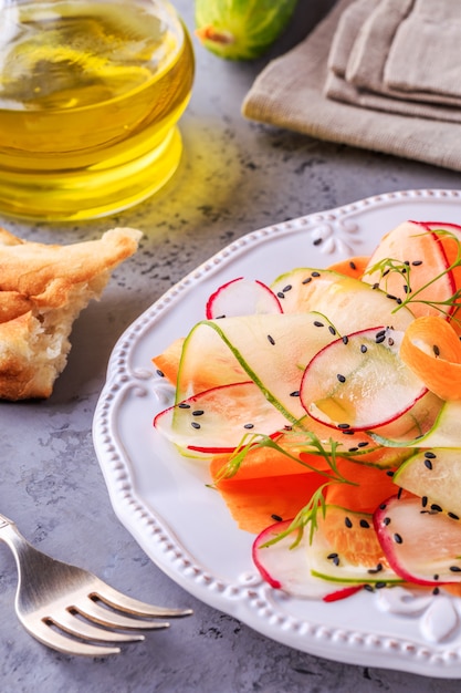 Vegetarian salad of carrot, cucumber and radish.