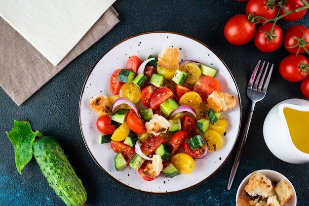 Vegetarian salad Panzanella with tomatoes onion and bread Croutons Dark background Top view Italian salad