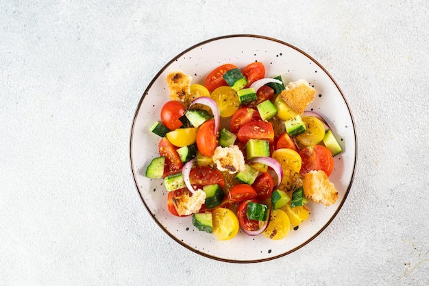 Vegetarian salad Panzanella with tomatoes onion and bread Croutons Light background Top view Italian salad