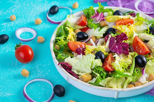 Vegetarian salad with chickpeas tomatoes olives and lettuce Diet salad food