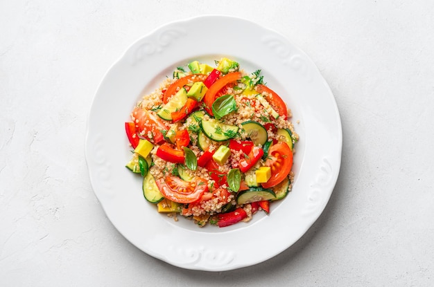 Vegetarian salad with quinoa avocado cucumber and sweet pepper on a gray background Healthy food