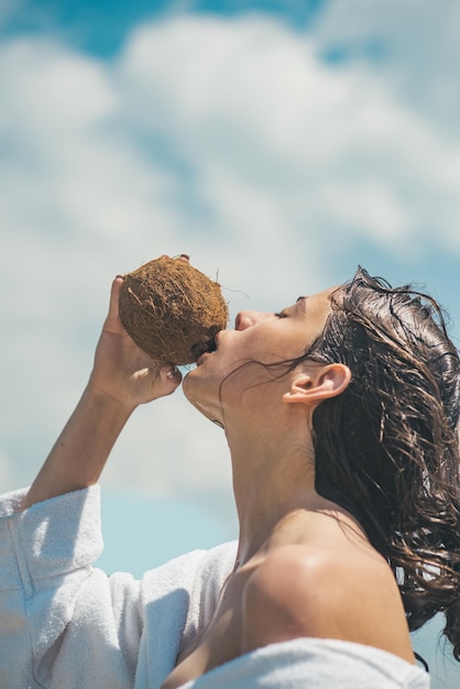 Vegetarian and vegan Woman is moisturizing her skin with a coconut cream coco milk drinking beach cocktail woman drinking coconut juice summer vacation coconut oil production