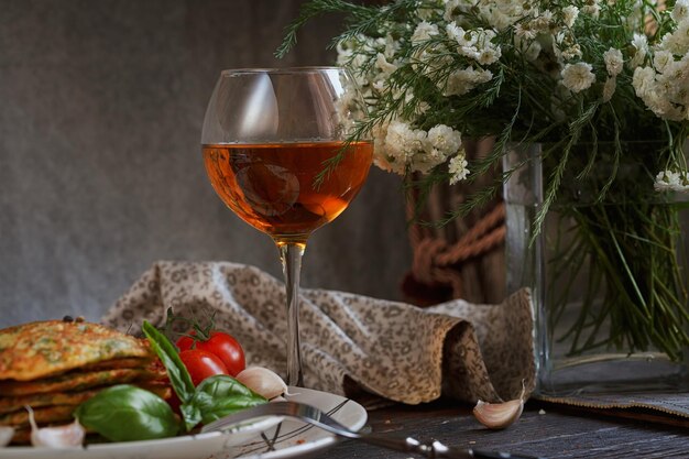 Vegetarian zucchini fritters served with fresh herbs tomatoes and garlic Romantic dinner with wine