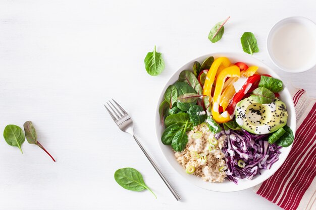 Veggie couscous lunch bowl with avocado, bell peppers, spinach and red cabbage