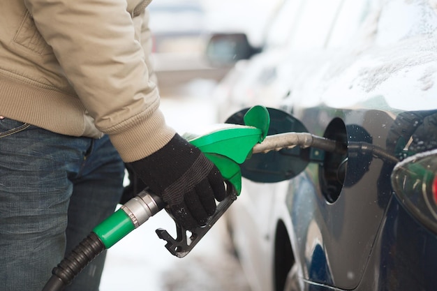 Photo vehicle and fuel concept - close up of male refilling car fuel tank