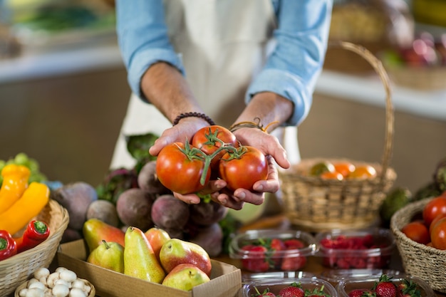 Vendor offering tomatoes at the counter