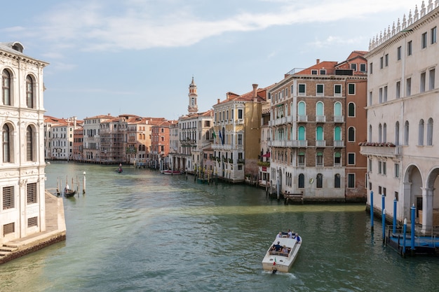 Venice, Italy - July 1, 2018: Panoramic view of Grand Canal (Canal Grande) from Rialto Bridge. It is a major water-traffic corridors in Venice city. Landscape of summer sunny day and blue sky