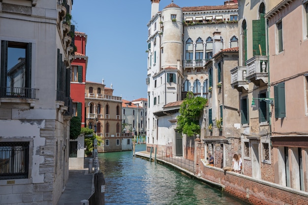 Venice, Italy - July 1, 2018: Panoramic view of Venice narrow canal with historical buildings and boats from bridge. Landscape of summer sunny day