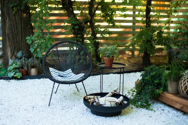 veranda house with armchairs table and plants pots fireplace bowl in garden on back yard patio