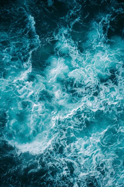 Vertical aerial view from above of turquoise ocean water with splashes