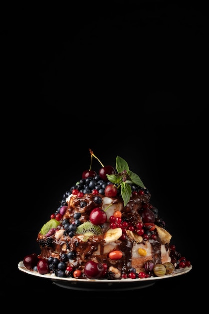 Vertical Beautiful cake decorated with various berries and fruits on a dark background