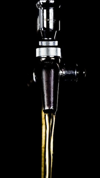 Vertical closeup of the beer tap on black background