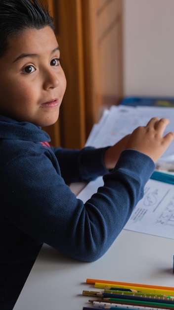 Vertical closeup of a Hispanic child studying at home