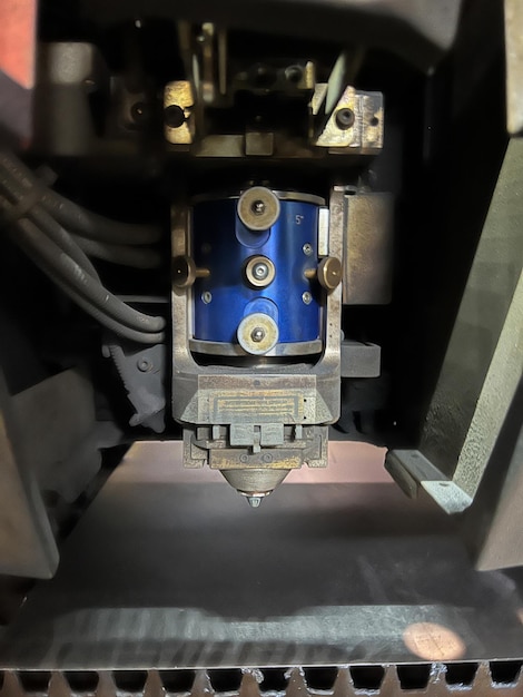 Vertical closeup of the lens and nozzle of a laser cutting machine metalworking industry