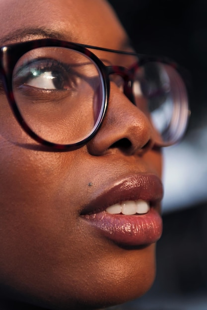 Vertical closeup portrait of a young black woman with glasses in profile concept of youth